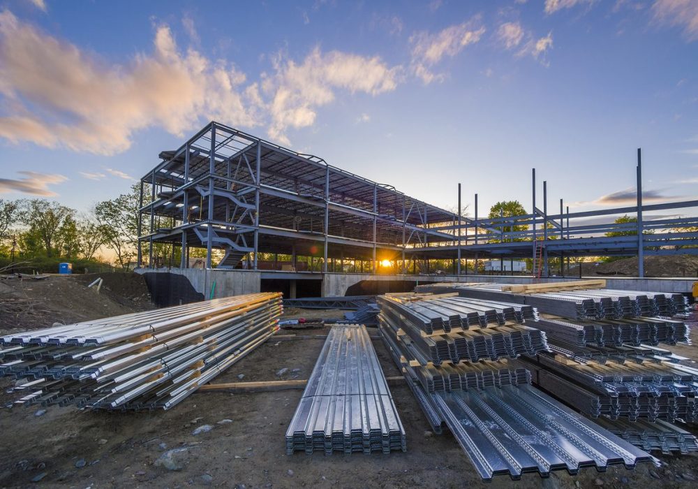 Construction site with steel flooring in front of a  partially erected building at sunset