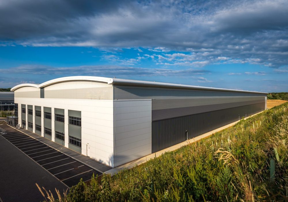 Industrial distribution warehouse construction frame in england uk sunset.